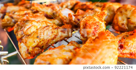 Cooking chicken skewers on the grill in the garden at sunset 92221174