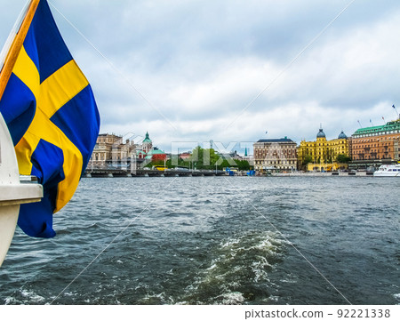 Panoramic view from the excursion boat with the flag of Sweden on the beautiful buildings of Stromkajen in the center of Stockholm Sweden Panoramic view from the excursion boat with the flag of Sweden on the beautiful buildings of Stromkajen in the center of Stockholm Sweden 92221338