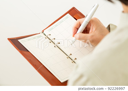 Middle-aged female business woman who opens a notebook 92226997