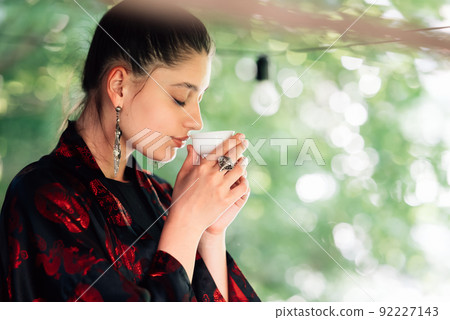 Shot of young woman drinking from tea bowl Shot of young woman drinking from tea bowl 92227143
