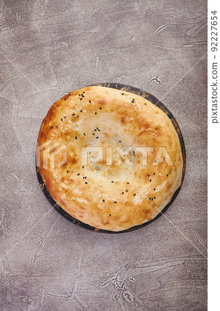 Delicious fresh tandir flatbread with black and white sesame seeds. National traditional Asian food Delicious fresh tandir flatbread with black and white sesame seeds. National traditional Asian food 92227654