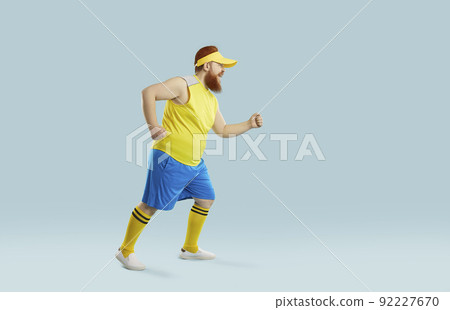 Funny fat man having weight loss workout and running isolated on blue background 92227670