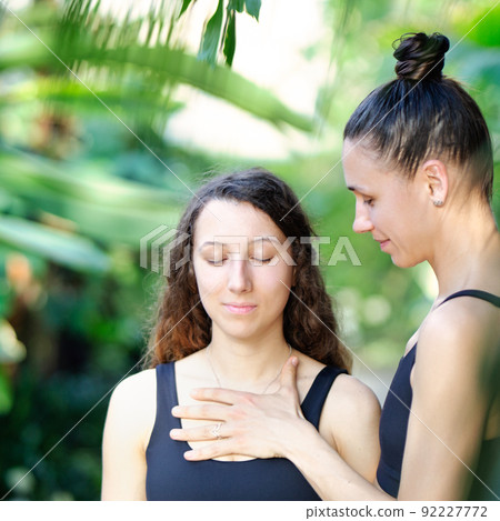 Yoga concept, meditation and sound therapy. Beautiful young girl at yoga session with her yoga and meditation teacher at tropical yoga retrear 92227772