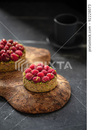 Two delicious raspberry tartlets with pistachios Two delicious raspberry tartlets with pistachios 92228073