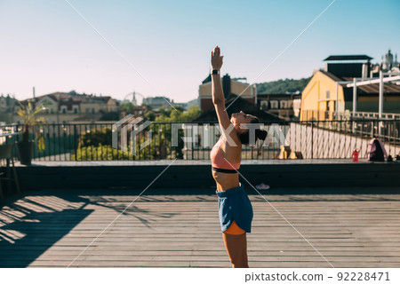 Young woman practicing yoga on the roof of a building 92228471