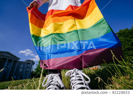 Cropped photo of young woman with LGBT pride flag. 92228633