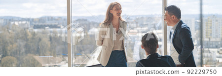 Team of young businessmen communicating together in modern office with panoramic windows 92229750