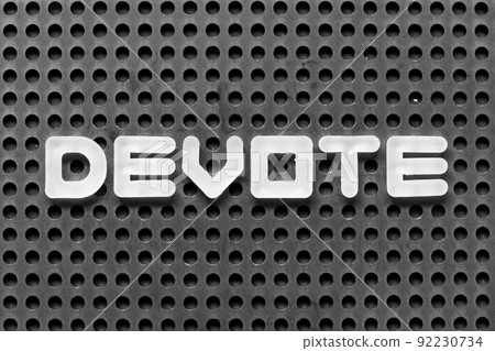 White alphabet letter in word devote on black pegboard background White alphabet letter in word devote on black pegboard background 92230734