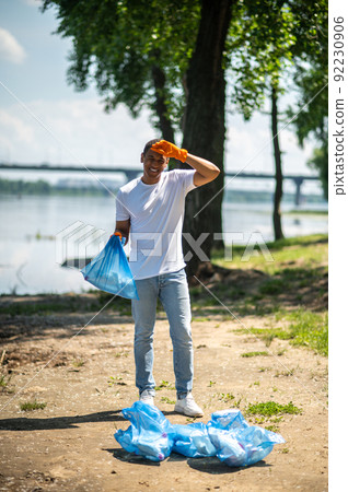 Guy in gloves holding bag smiling at camera 92230906