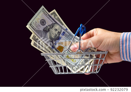 businessman hand with dollars in a grocery basket. financial investments in business 92232079