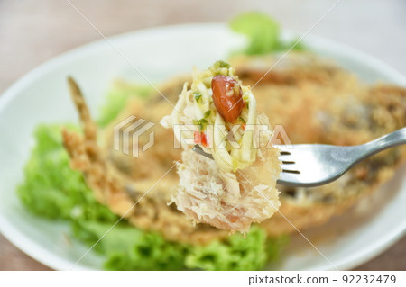 deep fried black-banded trevally fish with flake bread on plate dipping spicy and soy mango sauce deep fried black-banded trevally fish with flake bread on plate dipping spicy and soy mango sauce 92232479