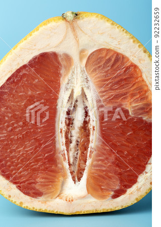 Grapefruit minimal erotic concept. Half a juicy grapefruit close up on a colored background. Grapefruit minimal erotic concept. Half a juicy grapefruit close up on a colored background. 92232659