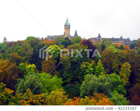 Luxembourg, view of the city from afar. Autumn green, red, yellow trees, spiers of towers of old houses in the distance. Beautiful landscape 92233387