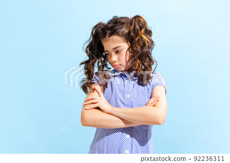 Portrait of winsome little girl,school age kid in summer dress isolated over blue background. Concept of children emotions, fashion, beauty, school and ad 92236311