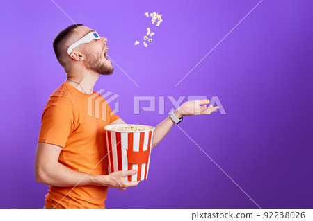 young man in 3d glasses throwing up and eating popcorn young man in 3d glasses throwing up and eating popcorn 92238026