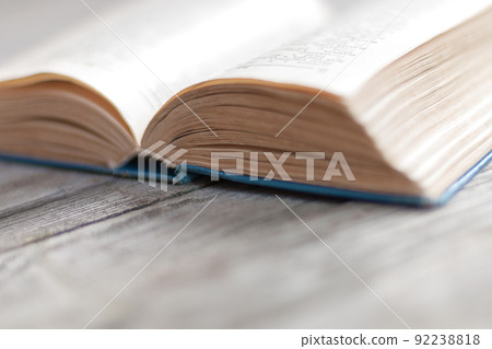 Open old-fashioned paper book backlit with daylight Open old-fashioned paper book backlit with daylight 92238818