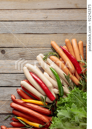 Various sausages with salad,  rosemary, and hot peppers. 92242875