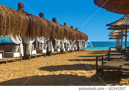 View of deck chairs and umbrellas on the sandy beach of Kemer, Turkey. 92243207