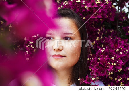young pretty brunette girl surrounded by purple flowers, lifstyle people touristic season close up young pretty brunette girl surrounded by purple flowers, lifstyle people touristic season close up 92243392