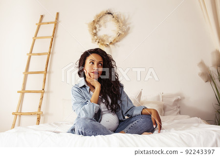 young pretty african american woman pregnant laying in bed, lifestyle people concept close up young pretty african american woman pregnant laying in bed, lifestyle people concept close up 92243397
