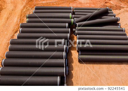 PVC new black plastic pipes stacked in rows at construction site on reconstruction PVC new black plastic pipes stacked in rows at construction site on reconstruction 92245541