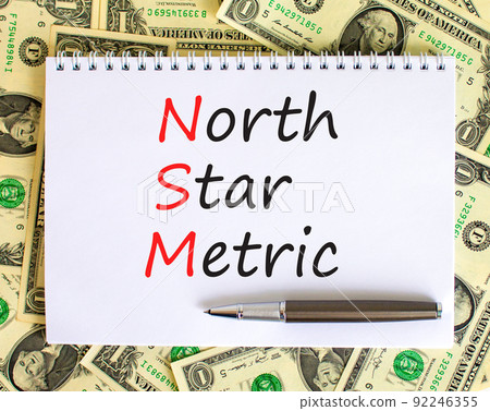 NSM north star metric symbol. Concept words NSM north star metric on white note on a beautiful background from dollar bills. Metallic pen. Business and NSM north star metric concept. Copy space. NSM north star metric symbol. Concept words NSM north star metric on white note on a beautiful background from dollar bills. Metallic pen. Business and NSM north star metric concept. Copy space. 92246355