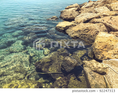 entrance to the sea from the pebble shore. clear, clear turquoise water for bathing tourists in the sea. clean shore, swimming in salty healthy water entrance to the sea from the pebble shore. clear, clear turquoise water for bathing tourists in the sea. clean shore, swimming in salty healthy water 92247313