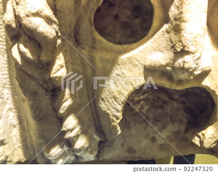 three-dimensional texture, plaster sculpture, ancient art. on the texture of scuffs, chips, cracks. creepy plaster mask with open mouth and large eye sockets 92247320