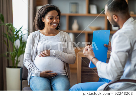 Pregnant black woman visiting doctor at private clinic 92248208
