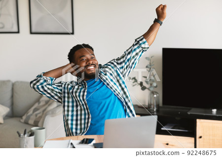 Relaxed Black Man Stretching Hands Sitting At Laptop At Home 92248675