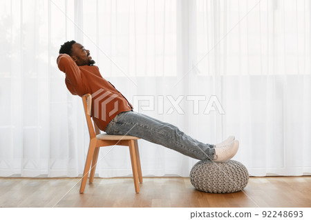 Relaxed African American Man Sitting In Chair At Home Relaxed African American Man Sitting In Chair At Home 92248693