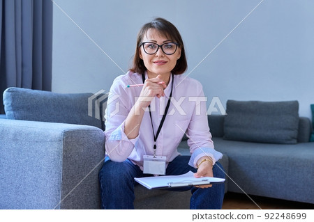 Portrait of female psychologist sitting on sofa in office Portrait of female psychologist sitting on sofa in office 92248699