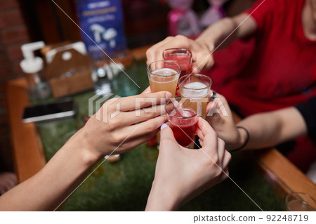 Celebrating with glasses of alcohol in hands. Happy female friends having good time. Celebrating with glasses of alcohol in hands. Happy female friends having good time. 92248719
