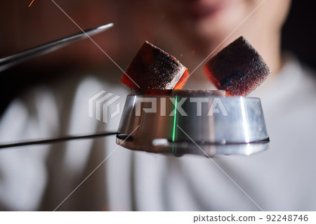 Burning red coals for hookah during preparation. Burning red coals for hookah during preparation. 92248746