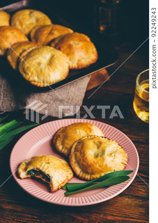 Freshly Baked Hand Pies Filled with Chives and Mushrooms. One Pie with Bite Taken Out of It Freshly Baked Hand Pies Filled with Chives and Mushrooms. One Pie with Bite Taken Out of It 92249243