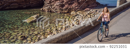 Woman tourist on a bicycle explores Budva in Montenegro. Cycling in Montenegro concept BANNER, LONG FORMAT 92251031