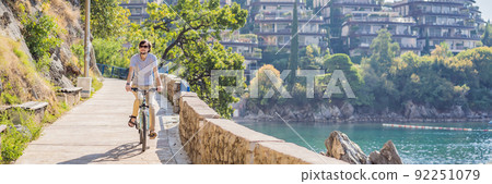 Man tourist on a bicycle explores Budva in Montenegro. Cycling in Montenegro concept BANNER, LONG FORMAT 92251079