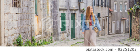 BANNER, LONG FORMAT Woman tourist on background of Scenic panorama view of the historic town of Risan at famous Bay of Kotor on a beautiful sunny day with blue sky and clouds in summer, Montenegro BANNER, LONG FORMAT Woman tourist on background of Scenic panorama view of the historic town of Risan at famous Bay of Kotor on a beautiful sunny day with blue sky and clouds in summer, Montenegro 92251202
