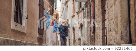 BANNER, LONG FORMAT Mom and son travelers enjoying Colorful street in Old town of Kotor on a sunny day, Montenegro. Travel to Montenegro concept BANNER, LONG FORMAT Mom and son travelers enjoying Colorful street in Old town of Kotor on a sunny day, Montenegro. Travel to Montenegro concept 92251465