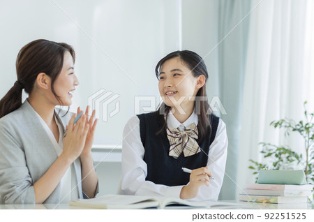 Female students receiving individual guidance at a cram school High school students Junior high school students 92251525