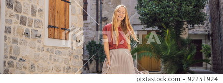 BANNER, LONG FORMAT Woman tourist enjoying Colorful street in Old town of Kotor on a sunny day, Montenegro. Travel to Montenegro concept 92251924