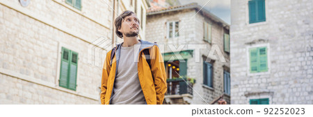 BANNER, LONG FORMAT Man tourist enjoying Colorful street in Old town of Kotor on a sunny day, Montenegro. Travel to Montenegro concept 92252023