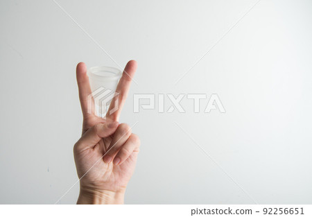the woman holds a menstrual cup in her hands  92256651