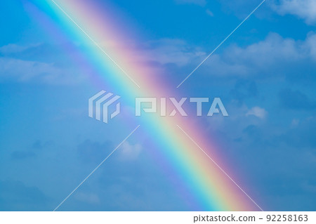 Close up on the rainbow over the blue sky where it rains 92258163