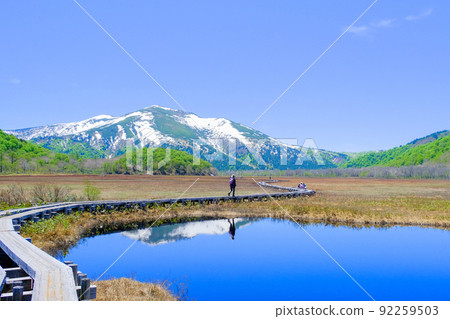 Hikers reflected in the swamp and Mt. Shibutsu 92259503
