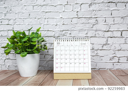 October 2022 white calendar with potted plant on wooden desk 92259983