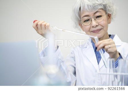 Senior woman in a lab coat doing an experiment 92261566