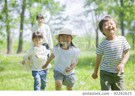 Children and nursery teachers playing in the spring park 92262625