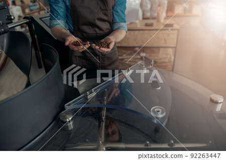 Baristas hands demonstrate freshly roasted coffee beans ready for selling 92263447