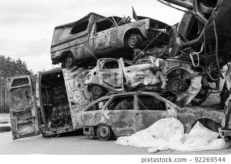 Dump of war-destroyed cars in Ukraine, black and white photo 92269544